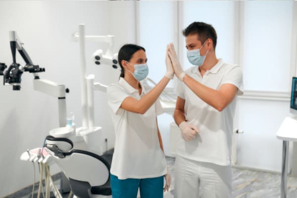 Dental staff giving each other a high five for success